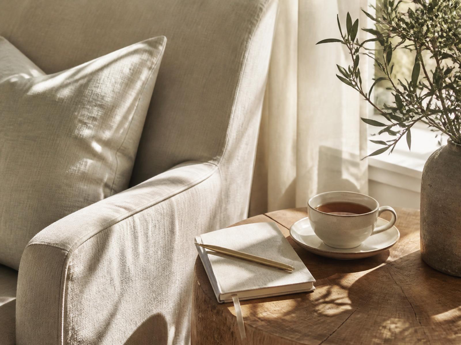 A quiet, sunlit sitting room with a notebook and a cup of tea